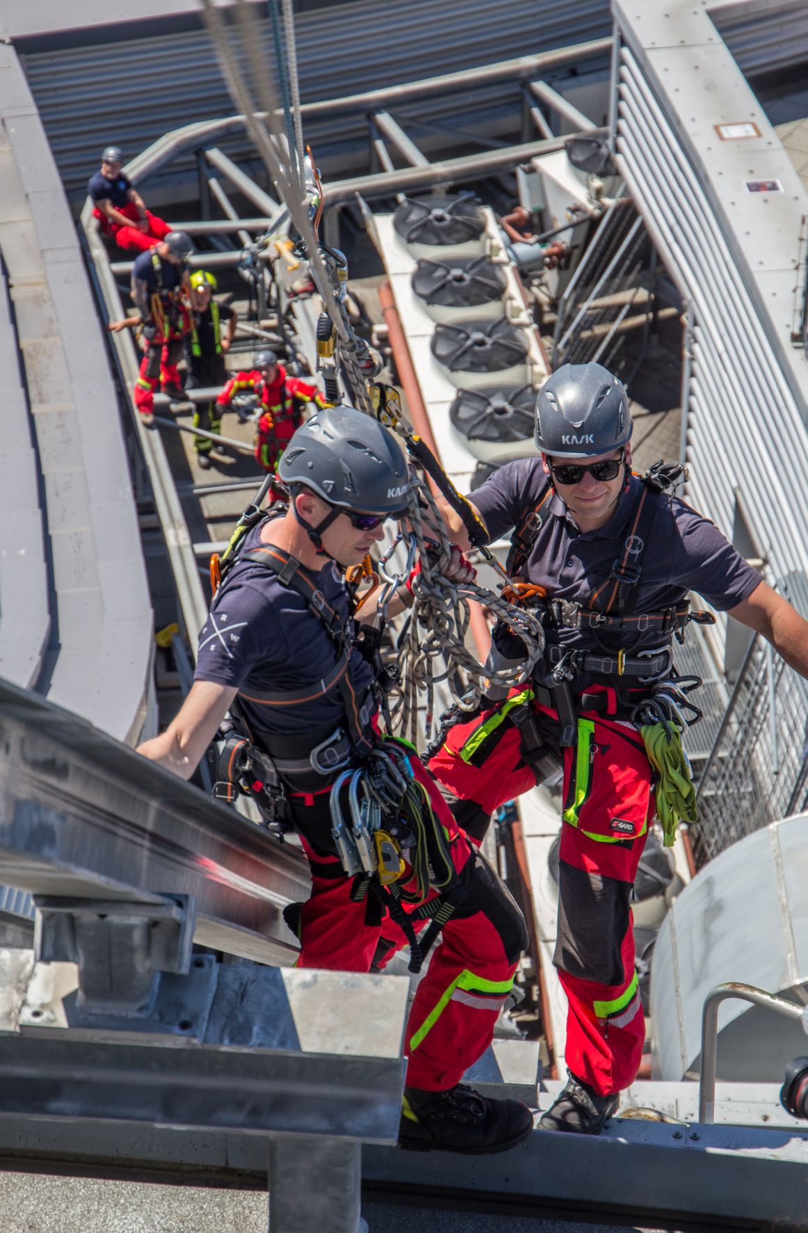 Zwei Feuerwehrmänner hängen gesichert vom Citytower Leipzig bei einem Probe-Rettungseinsatz.