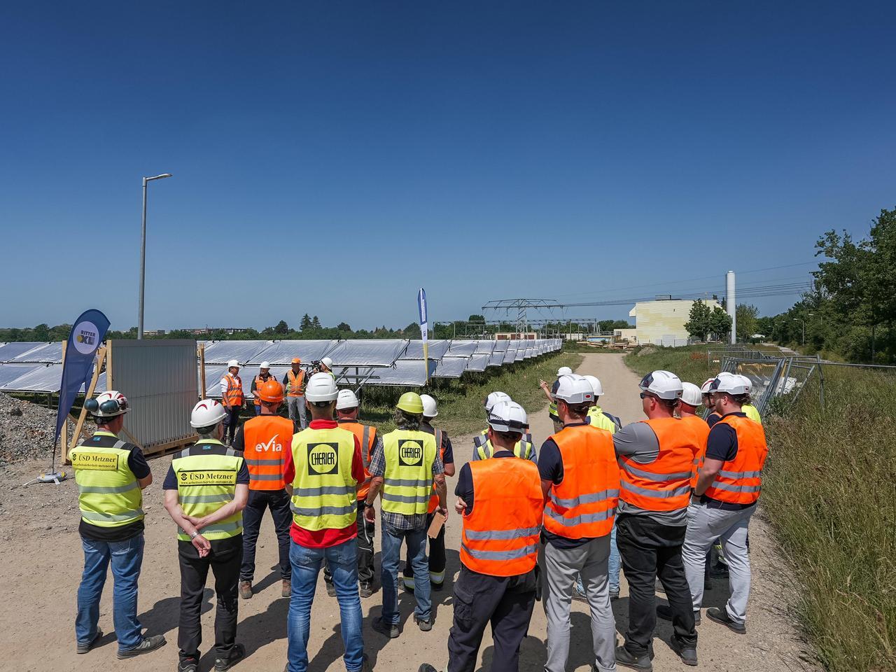 Eine Gruppe Bauarbeiter vor dem letzten Panel der Solarthermie