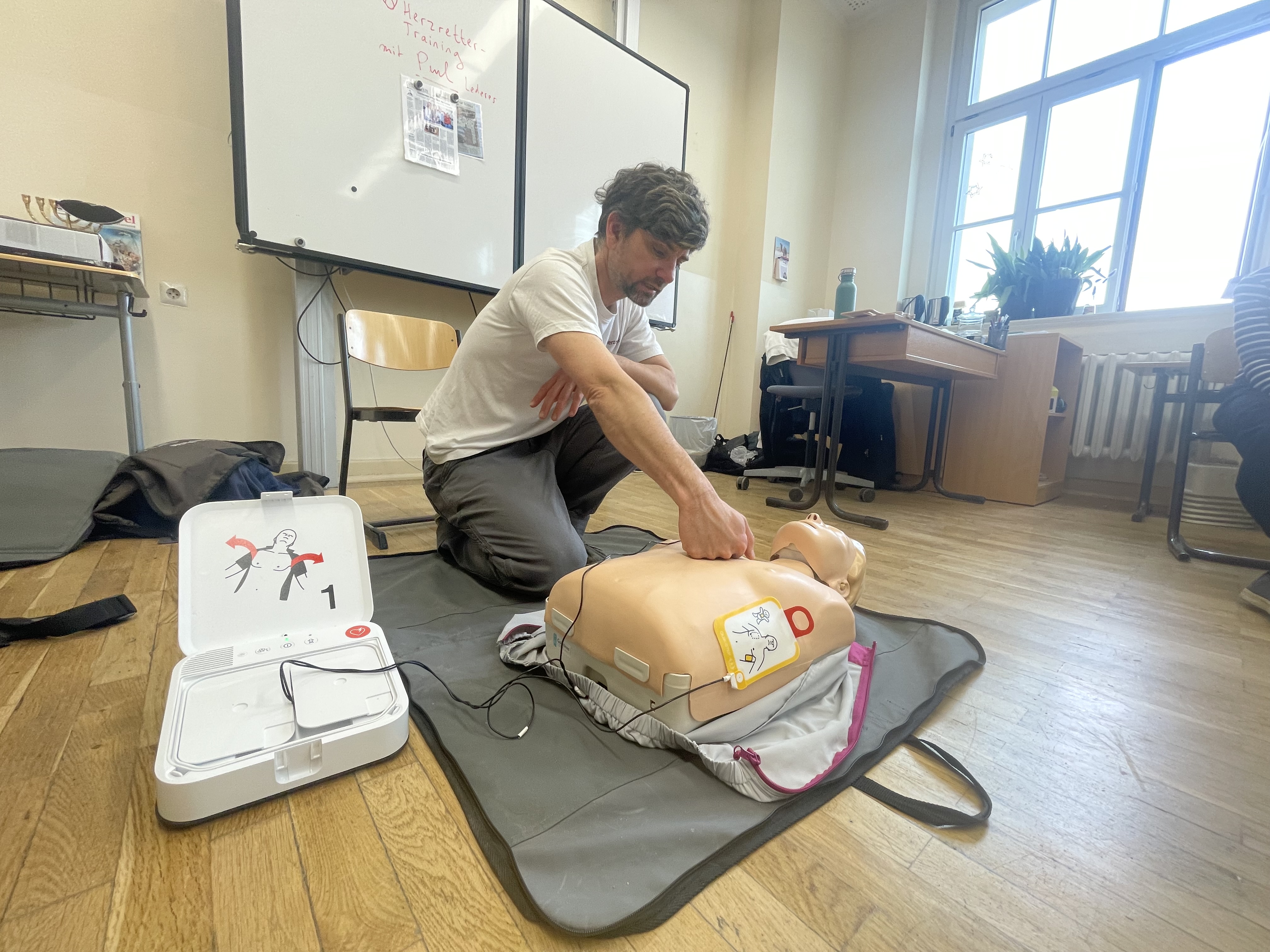 Paul Lederer zeigt an Clara Bernd, wie man den Defibrillator anlegt und aktiviert. 