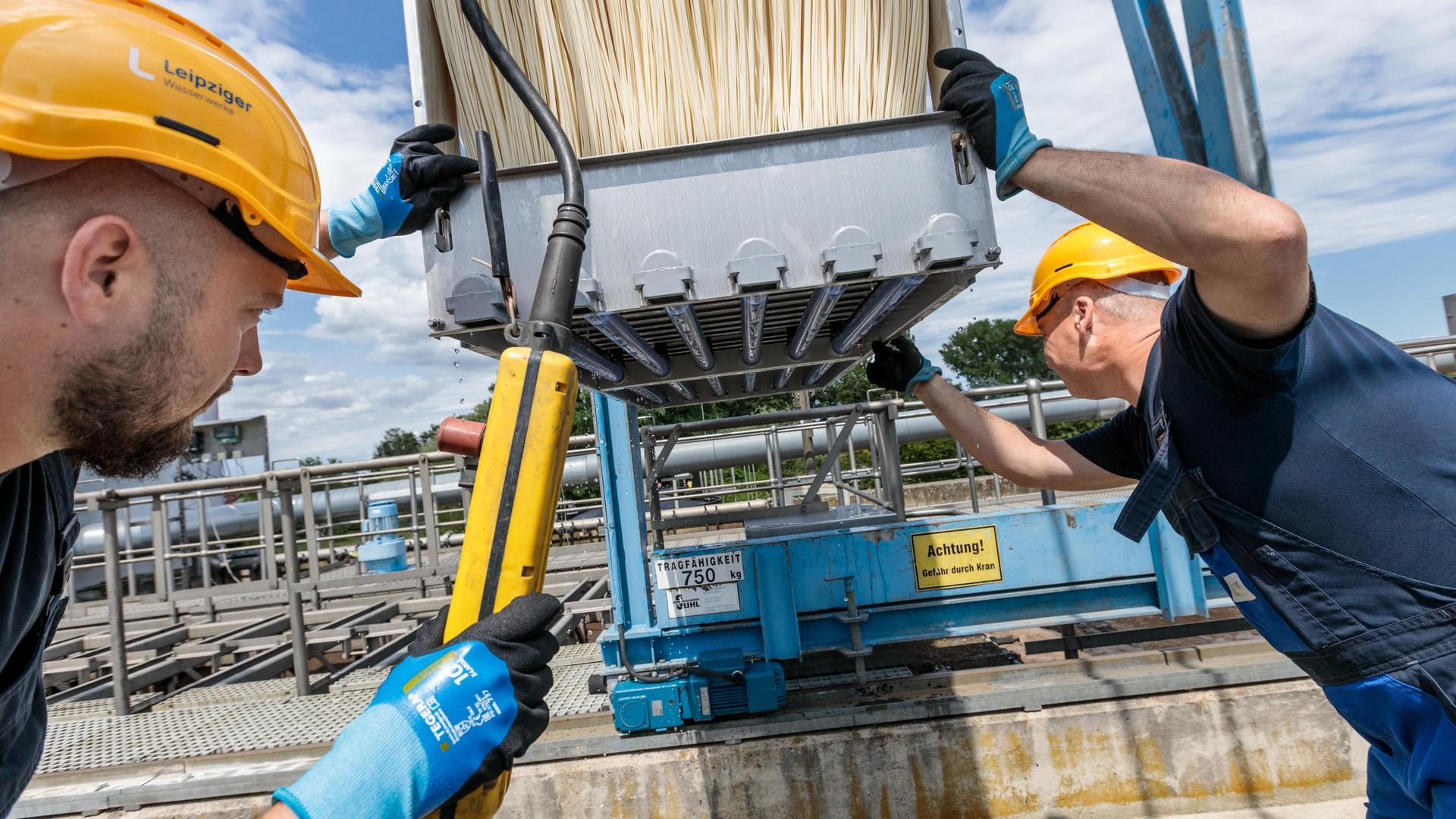Zwei Wasserwerker wechseln das Modul mit makkaronieförmigen Mikrofiltern in der Kläranlage Markranstädt
