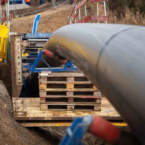 Das Kunststoffrohr wird über eine kleine Walze in den Schacht gezogen und dabei nach unten gebogen