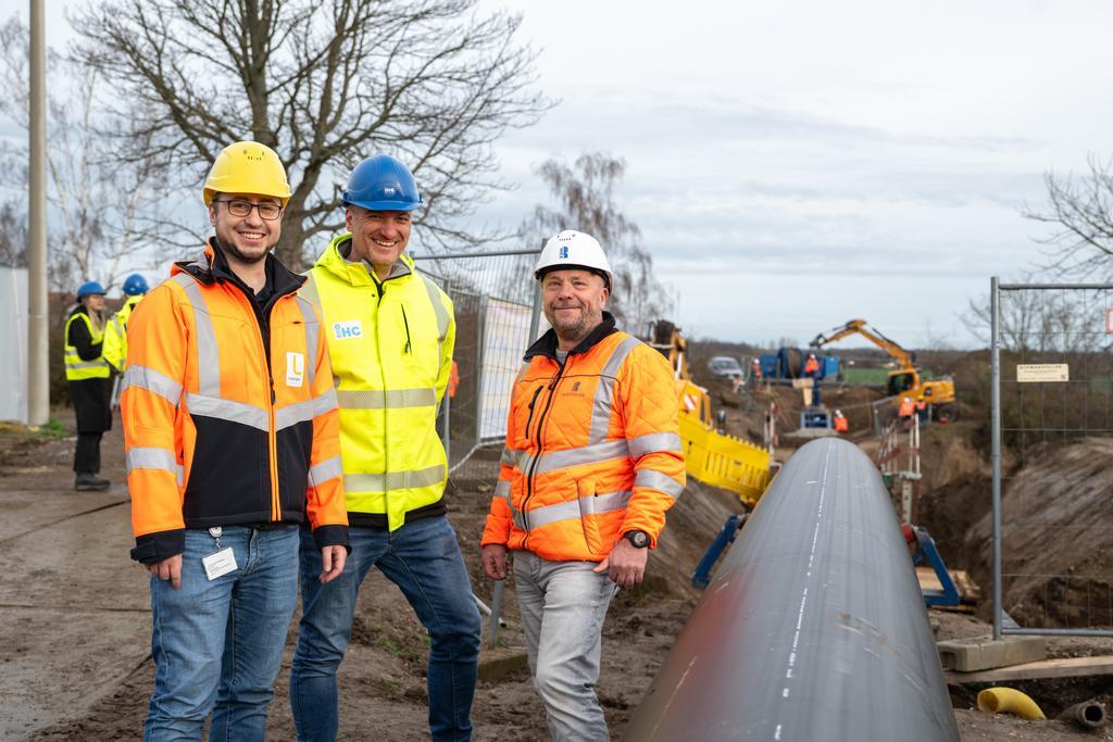 Wasserwerke-Projektleiter Benjamin Wolf (links) und die Fachleute der Spezialfirmen @Pfaffinger Leipzig Bau GmbH und @Umwelttechnik&Wasserbau GmbH stehen neben dem Rohr